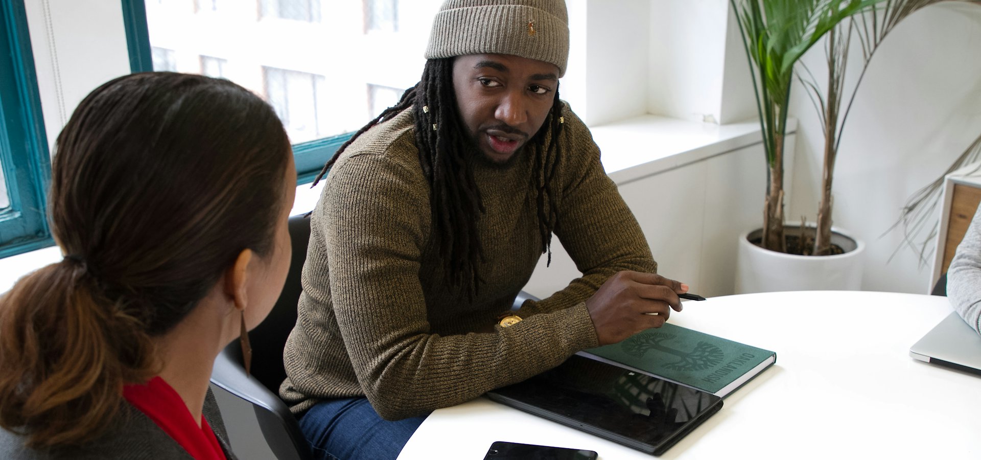 A consultant in conversation with a client at a meeting table