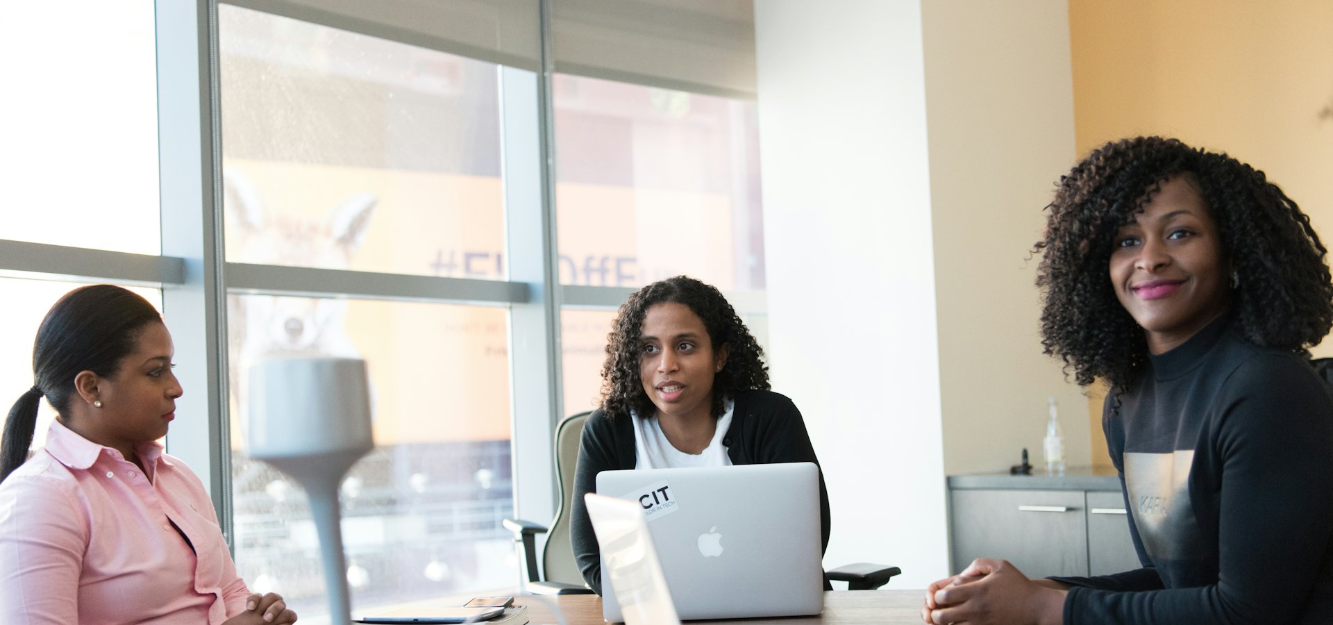 Three professionals in a meeting discussing people matters